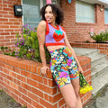 Nooworks cosmic floral bike shorts paired with a strawberry knit sweater vest
