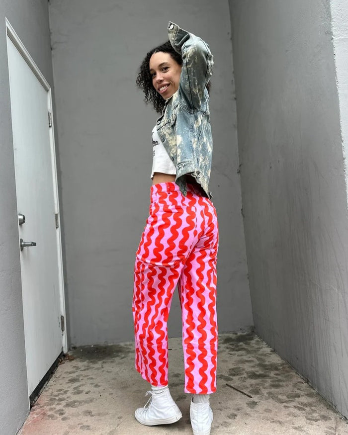 Nooworks pink squiggles skater pant paired with camo jacket and white sneakers