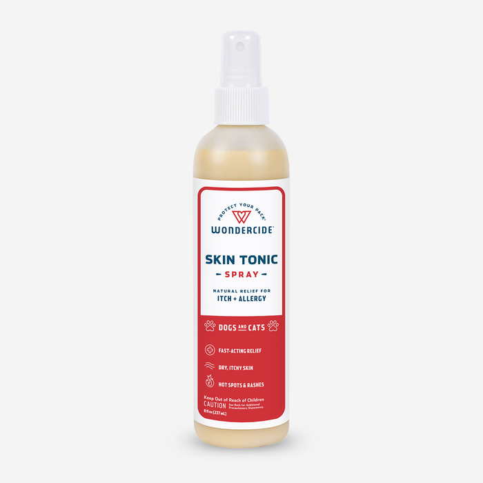 A bottle of Wondercide Skin Tonic Itch Spray for Dogs + Cats features a red and white label, promoting Natural Relief for Itch + Allergy with neem oil. It acts quickly, enhances skin health, and cautions to keep out of reach of children.